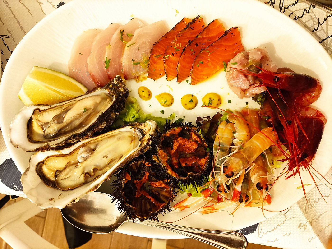 Fresh raw seafood platter with oysters, sea urchin, and prawns